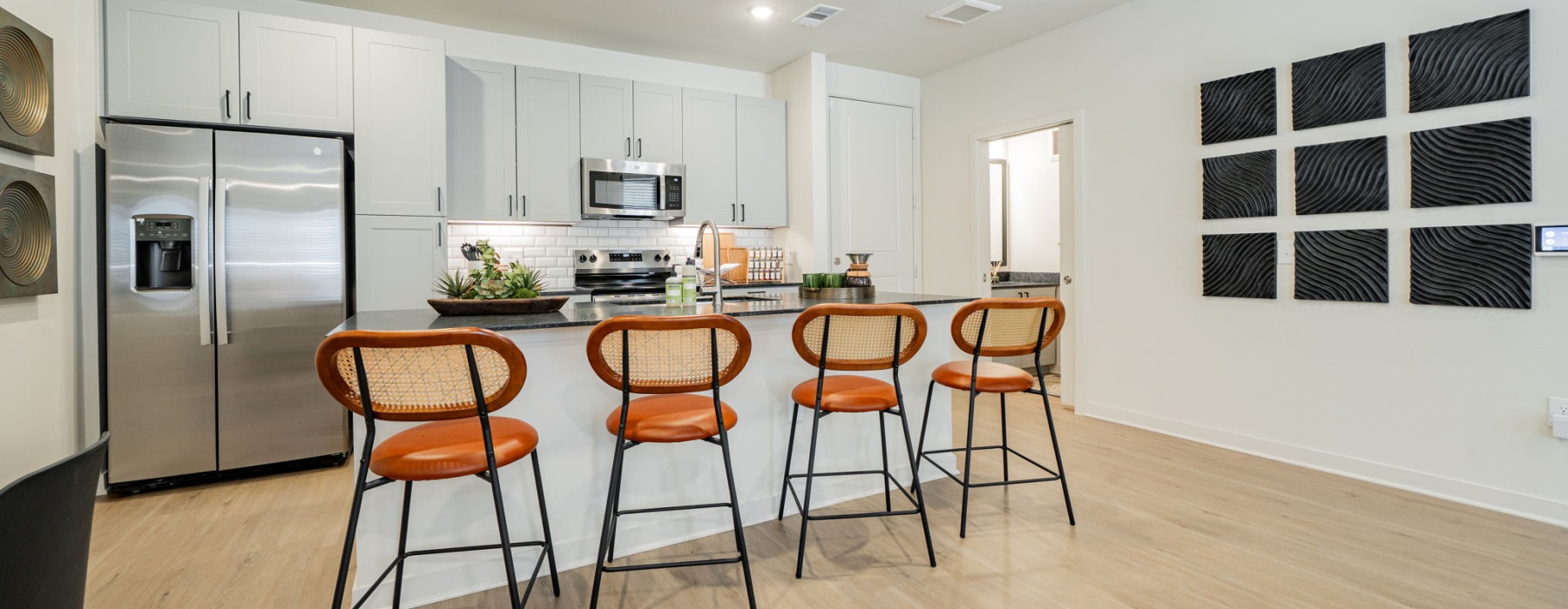 a kitchen with barstools and stainless steel appliances